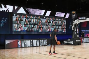 man throwing basketball in front of virtual fans
